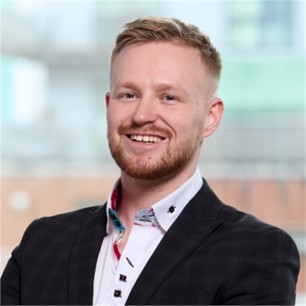 Dan Pearson in a black jacket and white shirt, in front of a window