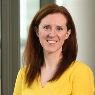 Carla Parsons in a yellow top, in front of a window