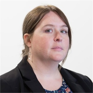 Charlotte Shaughnessy in a black jacket, in front of a pale background