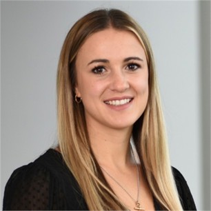 Ellie Knott in a black top, in front of a grey background