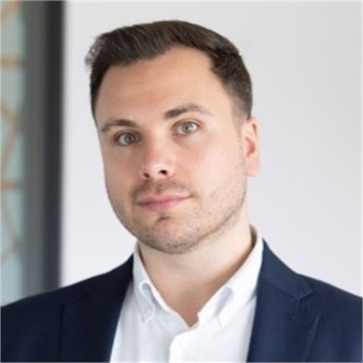 David Hickmott in a dark jacket and white shirt, in front of a pale background