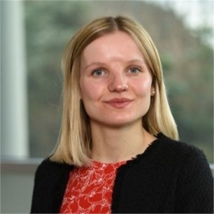 Chloe Campbell in a black jacket, in front of a window