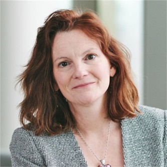 Claire Clarke in a grey jacket, in front of a pale background