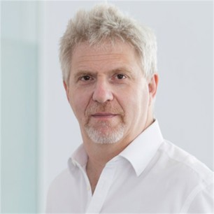 Clive Levontine in a white shirt, in front of a pale background